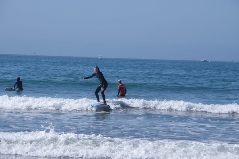 our student catching a wave during her surf lesson