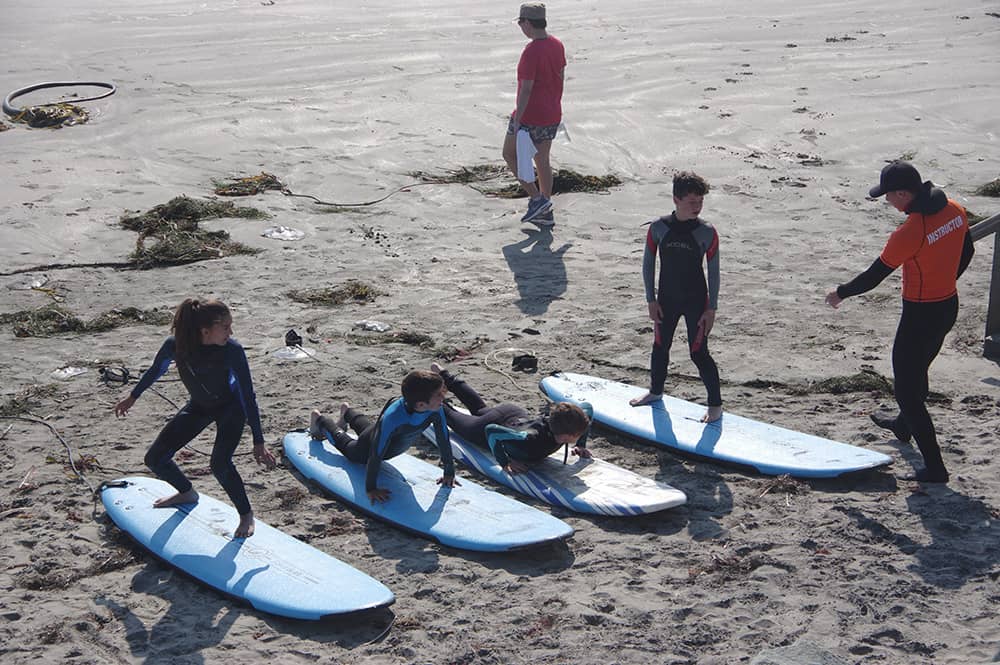 students on surf boards during surf lesson