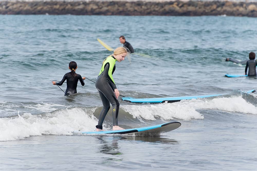 kid surfing a small wave at summer surf camp